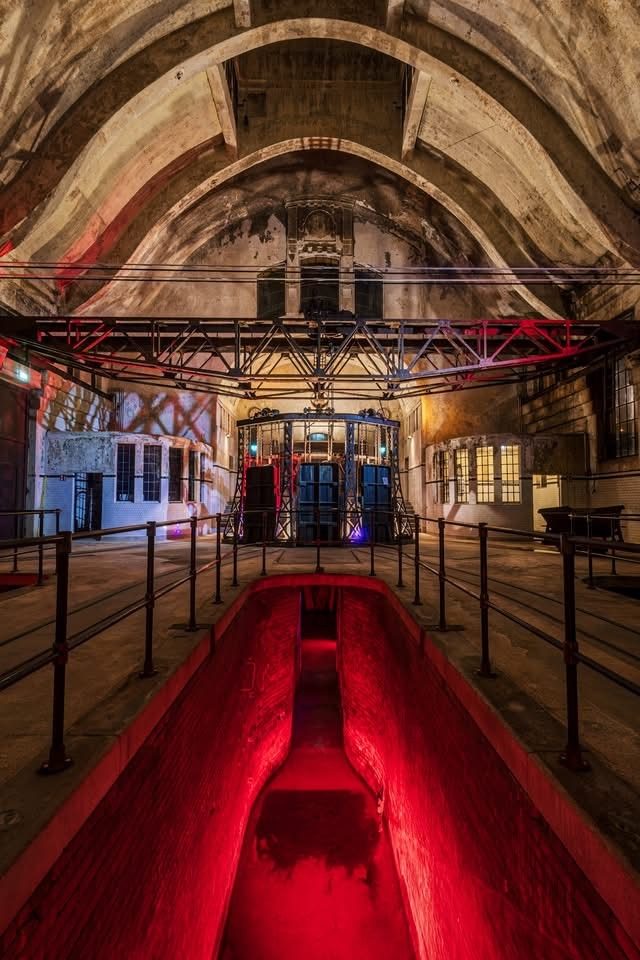 Historischer Klärkanal und technische Einbauten in der beleuchteten Klärhalle