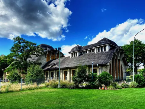 Historisches Klärwerk mit Garten und blauem Himmel
