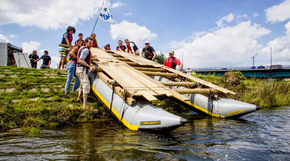 Team beim Floßbau am Wasser